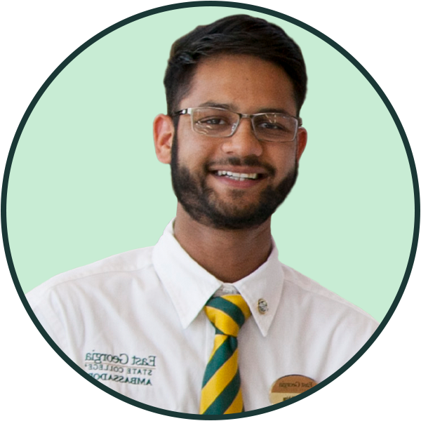 A smiling male student wearing an EGSC Ambassador shirt and tie